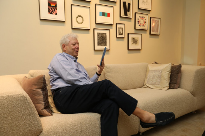This photo courtesy of Anne Ryan/University of Chicago shows Richard Thaler as he poses after winning the Nobel Prize on October 9, 2017, from his living room in Chicago, Illinois. US economist Richard Thaler won the Nobel Economics prize on Monday for showing that economic and financial decision-makers are not always rational, but mostly deeply human. Bridging the gap between economics and psychology, Thaler's research focuses on behavioural economics which explores the impact of psychological and social factors on decisions by individuals or groups in the economy and financial markets. / AFP PHOTO / University of Chicago / Anne RYAN / RESTRICTED TO EDITORIAL USE – MANDATORY CREDIT 