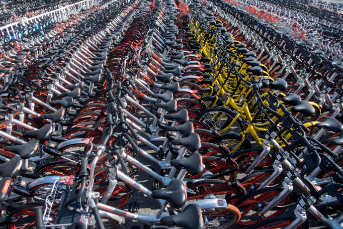This picture taken on March 1, 2017 shows impounded bicycles from the bike-sharing schemes Mobike and Ofo in Shanghai. Shanghai has impounded thousands of brightly coloured bikes placed on city streets by cycle-sharing companies, in the latest sign of impatience with an explosion of the haphazardly-parked two-wheelers. / AFP PHOTO / Johannes EISELE