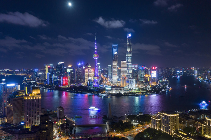 This picture taken on August 29, 2018 shows the moon shining over the financial district of Pudong in Shanghai. (Photo by Johannes EISELE / AFP)