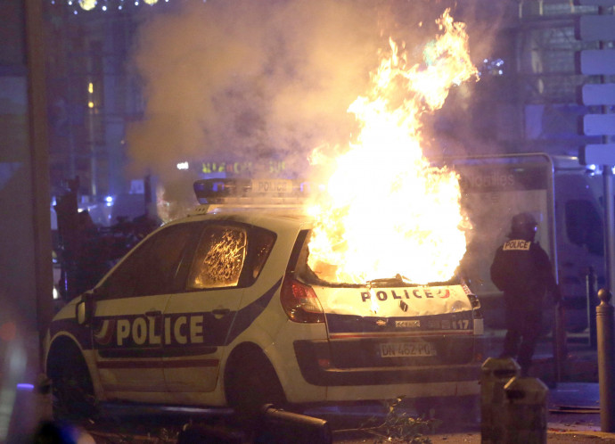 A sárga mellényes tüntetõk által felgyújtott rendõrautó ég Marseille-ben 2018. december 1-jén. A francia rendõrség szakszervezete rendkívüli állapot kihirdetését kérte a sárgamellényesek megmozdulásait kísérõ egyre erõszakosabb zavargások miatt. Fotó: MTI/AP/Claude Paris