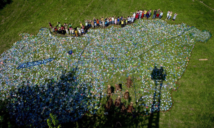 Hódmezõvásárhely, 2010. június 7. Gyermekek állnak egy közel hatszáz négyzetméteres, hatezer mûanyag palackból összeállított Magyarország térkép mellett, amelyet egy, a környezetvédelmi világnap alkalmából tartott figyelemfelhívó kezdeményezés keretében építettek meg Hódmezõvásárhelyen. MTI Fotó: Rosta Tibor