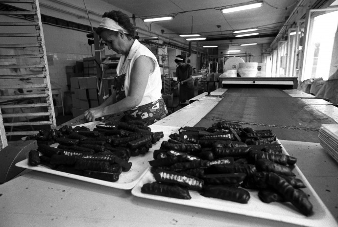 Az elkészült Túró Rudi-kat szedi le a szalagról egy nõ 1986-ban, a Heves megyei Sütõ és Édesipari Vállalat gyöngyösi gyárában. Fotó: MTI/H. Szabó Sándor