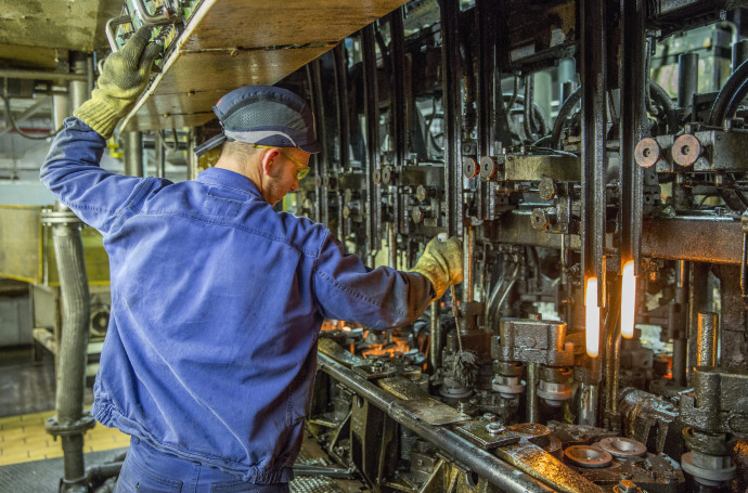 Üveggyártó gépsoron dolgozik egy munkatárs az O-I Manufacturing Magyarország Üvegipari Kft. orosházi üzemében. Fotó: Rosta Tibor/MTI