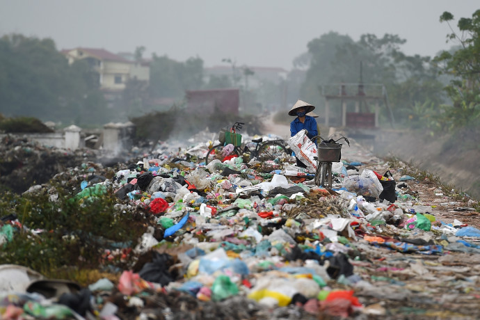 Vietnami nő válogat egy szemétkupacon. Fotó: AFP