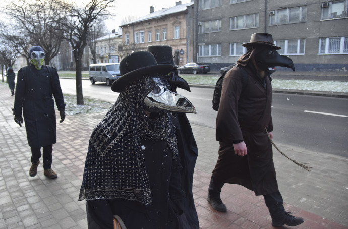 Pestisdoktor maszkot viselő Lvivben. A középkorban pestisdoktorok a madárcsõrre emlékeztető maszkba illatos növényeket raktak, hogy megakadályozzák a rossz levegõ belélegzését. Fotó: Pavlo Palamarcsuk/MTI/EPA