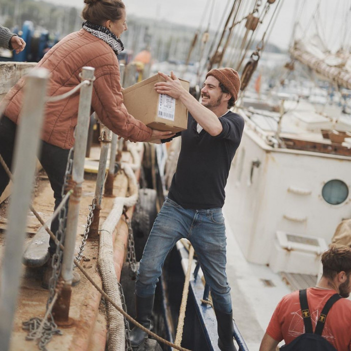 A Yallah munkatársai lepakolják a vitorlást, amellyel a kávé érkezett. Fotó: Yallah Coffee/Facebook