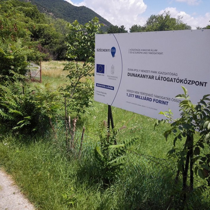 1,4 milliárd uniós támogatásról díszeleg tábla a térdig érő gazban