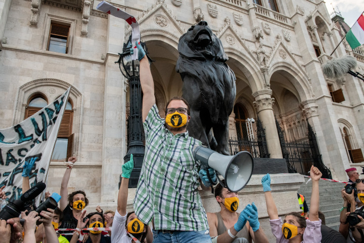 Csernai Mihály, a Színház- és Filmművészeti Egyetem HÖK-elnöke a Parlament előtt, kezében a chartával. Az egyetem hallgatói és szimpatizánsok élőlánccal tiltakoztak az SZFE modellváltása, autonómiájának elveszítése ellen 2020. szeptember 21-én Budapest belvárosában. Az élőlánc tagjai kézről kézre adták azt a chartát, amelyet az egyetem szenátusa írt. A Charta Universitasban rögzítették azokat az alapelveket, amelyek mentén el tudnák képzelni az együttműködést az Innovációs és Technológiai Minisztériummal.