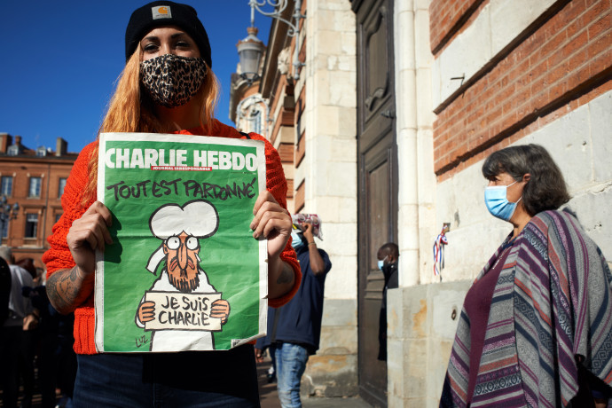 A Charlie Hebdónak a 2015-ös merénylet után megjelent számát tartja a kezében egy résztvevő a Samuel Paty meggyilkolásának harmadnapján tartott megemlékezésen 2020. október 18-ánFotó: Alain Pitton / NurPhoto / MTI