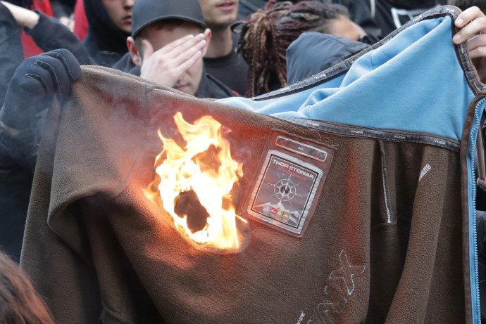 Egy tüntető Thor Steinar ruhát éget Berlinben 2015. május 1-jén. Fotó: Michael Kappeler / Getty Images