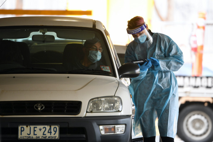 Egészségügyi alkalmazottak vizsgálati mintát vesznek koronavírustesztre egy melbourne-i bevásárlóközpontban kialakított autós tesztközpontbanFotó: MTI/EPA/AAP/James Ross