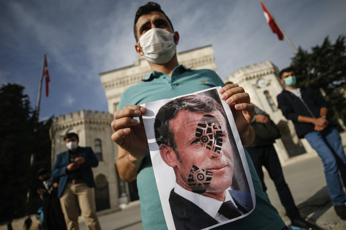 Egy török tüntető Emmanuel Macron francia elnök fényképét tartja kezében, amelyen egy cipőtalp lenyomata látható. A kép azután készült, hogy Macron erőteljesebb fellépést ígért a radikális iszlamistákkal szemben Fotó: MTI/AP/Emrah Gürel