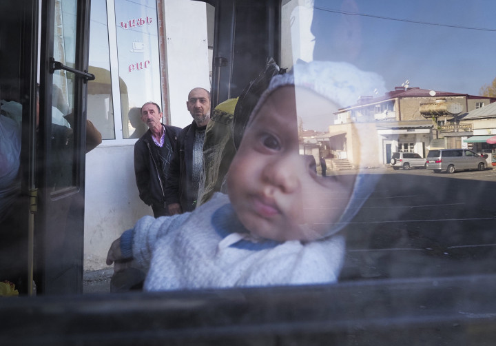 A harcok miatt Hegyi-Karabah székhelyéről, Sztyepanakertből távozó édesanyjával ül buszon egy csecsemő 2020. október 30-án Fotó: MTI/AP