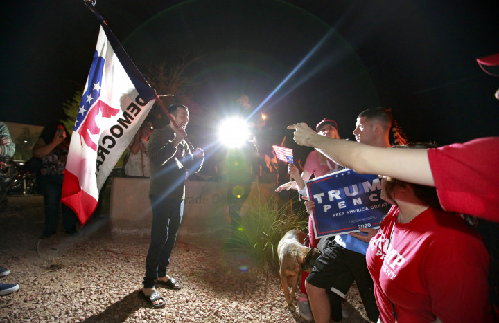Trump-szimpatizánsok és egy demokrata zászlót tartó férfi vitatkoznak a Clark megyei választási iroda előtt Las Vegasban, Nevada államban – Fotó: Ronda Churchill / AFP