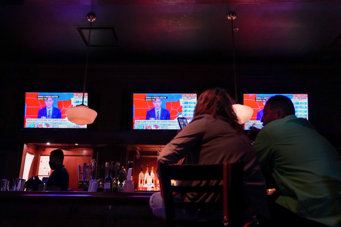 A választás eredményeit nézik a tévében az emberek egy washingtoni bárban 2020. november 6-án éjjel. Fotó: REUTERS / Erin Scott
