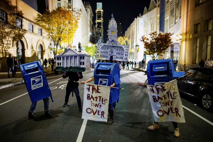 Postaládának és a Fehér háznak beöltözött aktivisták a pennsylvaniai Philadelphiában, a transzparensen a következő olvasható: „A csatának még nincs vége” – fotó: Eduardo Munoz / Reuters