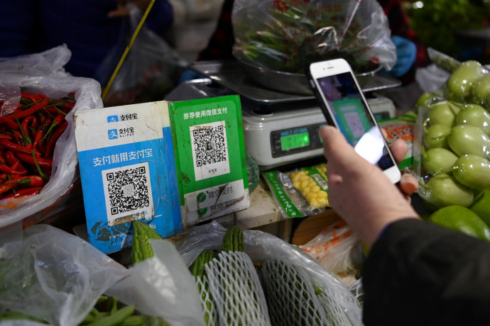Fizetés a zöldségesnél, QR-kóddal. (GREG BAKER / AFP)