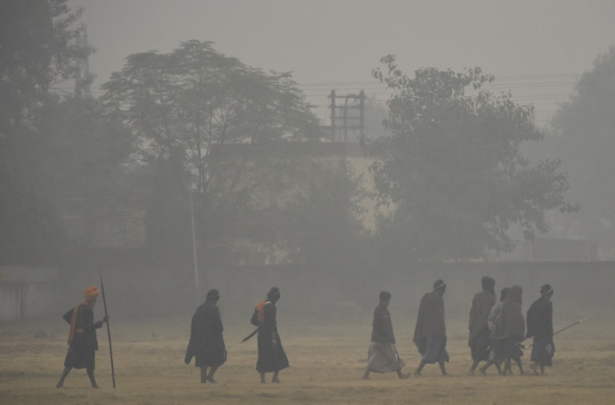 Szikh vallású emberek sétálnak a szmogban vasárnap reggel – Fotó: Narinder Nanu / AFP