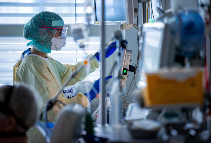 Egészségügyi dolgozó egy Covid-19 beteg ágya mellett november 23-án a németországi Greifswaldi Egyetemi Kórház intenzív osztályának különlegesen védett részén. Fotó: Jens Büttner / picture alliance via Getty Images