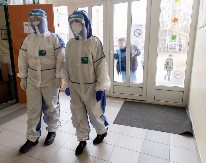 A koronavírus-teszteket végző, védőruhát viselő egyetemi hallgatók érkeznek egy mosonmagyaróvári általános iskolába 2020. november 24-én – Fotó: Krizsán Csaba / MTI