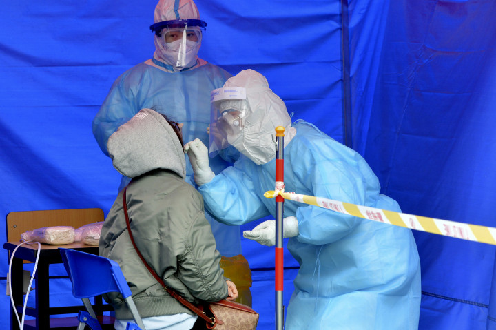 Egészségügyi dolgozók koronavírus-tesztre vesznek mintát a kínai Tiencsinben november 21-én. Fotó: MTI/AP/Chinatopix