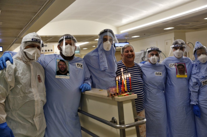 Izraeli orvosok egy felgyógyult beteggel ünneplik a hanukát Tel Avivban december 15-én. Fotó: Gil Cohen-Magen / AFP