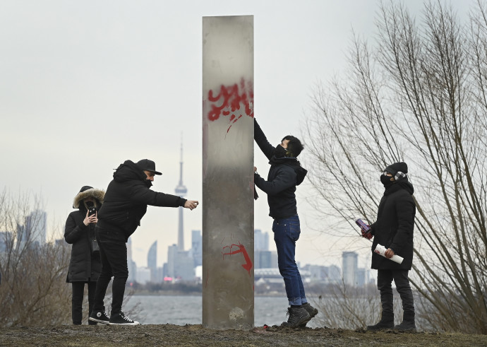 Egy közel négy méter magas monolit fémobjektumról próbálja a rongálás nyomait eltávolítani egy férfi a torontói Humber Bay Parkban 2021. január 1-jén. Forrás: MTI/The Canadian Press