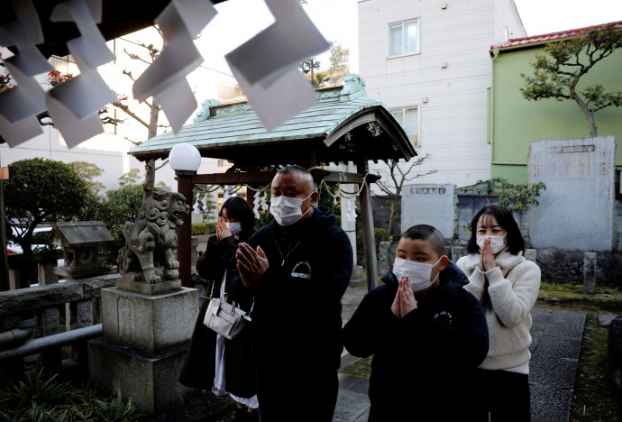 Kumagai Kjuta családjával imádkozik sikereiért a szumók istenéhez az újév első templomi látogatásán Tokióban, 2021. január 1-jén – Fotó: Kim Kyung-Hoon / Reuters