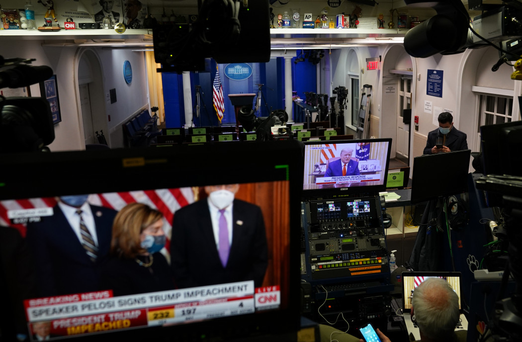 Donald Trump videón beszél a Fehér Ház Twitterén, miközben a másik monitoron Nancy Pelosi látható, miután aláírta a vádemelésről szóló alsóházi határozatot 2021. január 13-án – Mandel NGAN / AFP