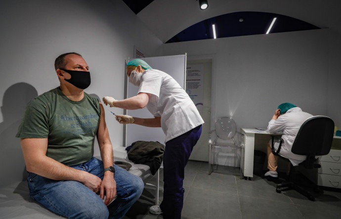Az új koronavírus ellen oltanak be egy férfit a moszkvai GUM áruházban létesített oltóközpontban 2021. január 19-én. Az oltásokhoz jelenleg az orosz fejlesztésű Szputnyik V vakcinát alkalmazzák Oroszországban – Fotó: Jurij Kocsetkov / EPA / MTI
