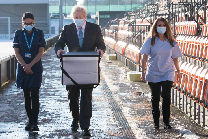 Boris Johnson visz egy pakk AstraZeneca oltóanyagot egy észak-londoni oltóponton 2021. január 25-én – Fotó: Stefan Rousseau / POOL / AFP