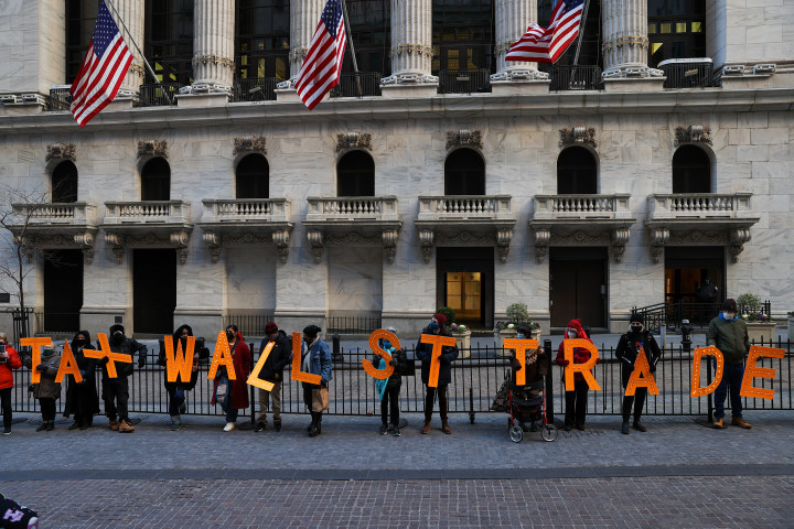 Tüntetők tiltakoznak a Robinhood döntése ellen a New York Stock Exchange előtt 2021. január 28-án. A kezükben lévő felirat szabad fordításban: „Adóztassuk meg a Wall Street-i kereskedelmet” – Fotó: Tayfun Coskun / Anadolu Agency / Getty Images
