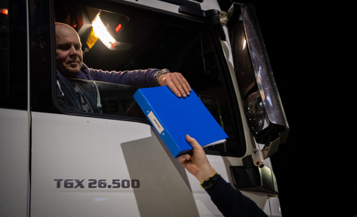 Egy angliai rákhalász cég kamionsofőrje adja át a szállítmány dokumentációját az országból való kilépés előtt egy vámügyintézőnek az angliai Weymouth kikötőjében 2021 januárjában – Fotó: Finnbarr Webster / Getty Images
