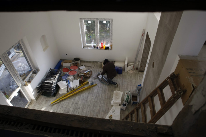 Szakember dolgozik egy családi házban Szolnokon – Fotó: Bugány János / MTI