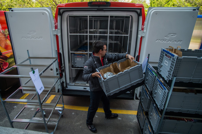 Egy dolgozó a megrendelt árukat pakolja a hűtésre és fagyasztásra alkalmas kisteherautóba egy élelmiszerwebshop háttérterületén 2019. május 8-án – Fotó: Balogh Zoltán / MTI