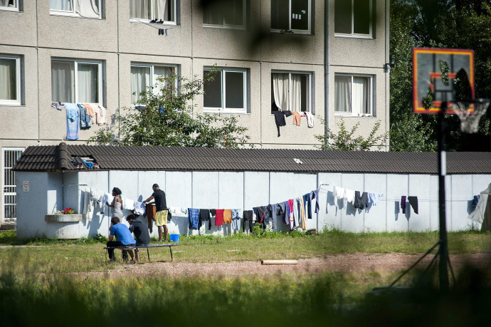 Egy férfi ruhákat tereget a vámosszabadi menekülttábor udvarán 2015-ben – Fotó: Krizsán Csaba / MTI