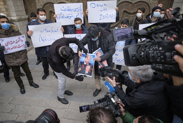 A teheráni külügyminisztérium épülete előtt tüntetők Donald Trump és Joe Biden amerikai elnökök portréit égetik el Moszen Farizade iráni nukleáris tudós meggyilkolása elleni tüntetésen 2020. november 28-án – Fotó: Morteza Nikoubazl / NurPhoto / AFP