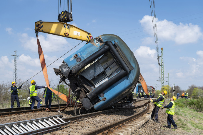 Fent: az előző nap kisiklott vonat kocsijának mentése, alul a 16 méterre sodródott mozdony – Fotó: Balázs Attila / MTI