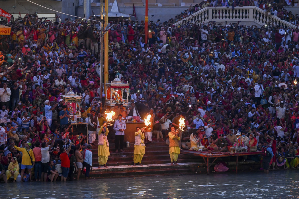 A hindu résztvevők a Kumbh Mela fesztiválon Haridvárban 2021. március 11-én, a Gangesz folyóban való megmártózást esti ima követi – Fotó: Prakash Singh / AFP