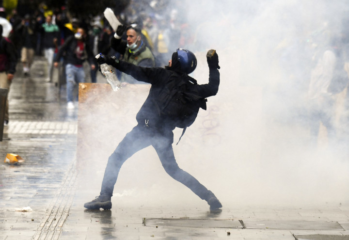 Egy tüntető követ dob a rohamrendőrökre a Bolívar téren – Fotó: Juan Barreto / AFP