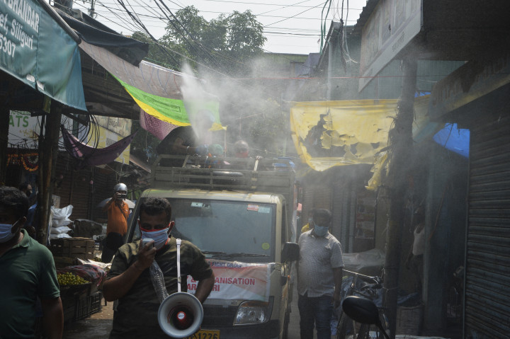 Civil szervezet önkéntesei fertőtlenítik az utcát Silinguriban, egy vásártérnél – Fotó: Diptendu Dutta / AFP