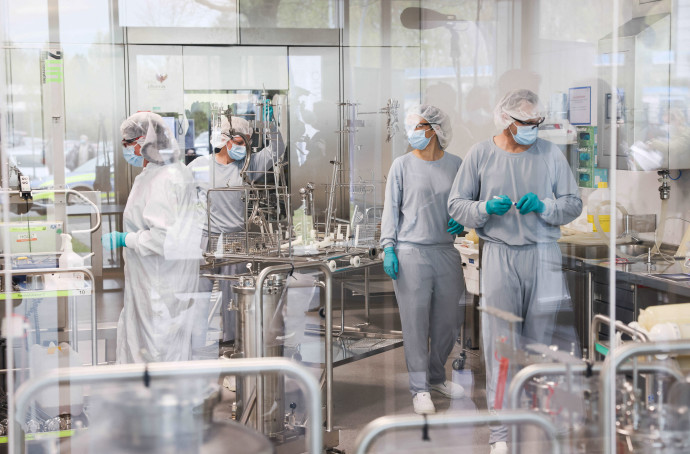 Employees work on the production of the Comirnaty vaccine by Biontech Pfizer in the Allergopharma production facilities in Reinbek, near Hamburg, northern Germany, on April 30, 2021, as the company started production of the vaccine, amid the coronavirus (Covid-19) pandemic. (Photo by Christian Charisius / POOL / AFP)