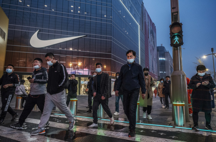 Emberek sétálnak el egy Nike üzlet előtt Peking bevásárlónegyedében 2021 márciusában – Fotó: Kevin Frayer / Getty Images