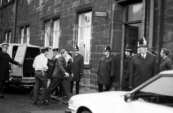 A hasfelmetszőt letakarva kísérik a rendőrök Leedsben a bíróság tárgyalótermébe 1981 februárjában – Fotó: PA Images / Getty Images