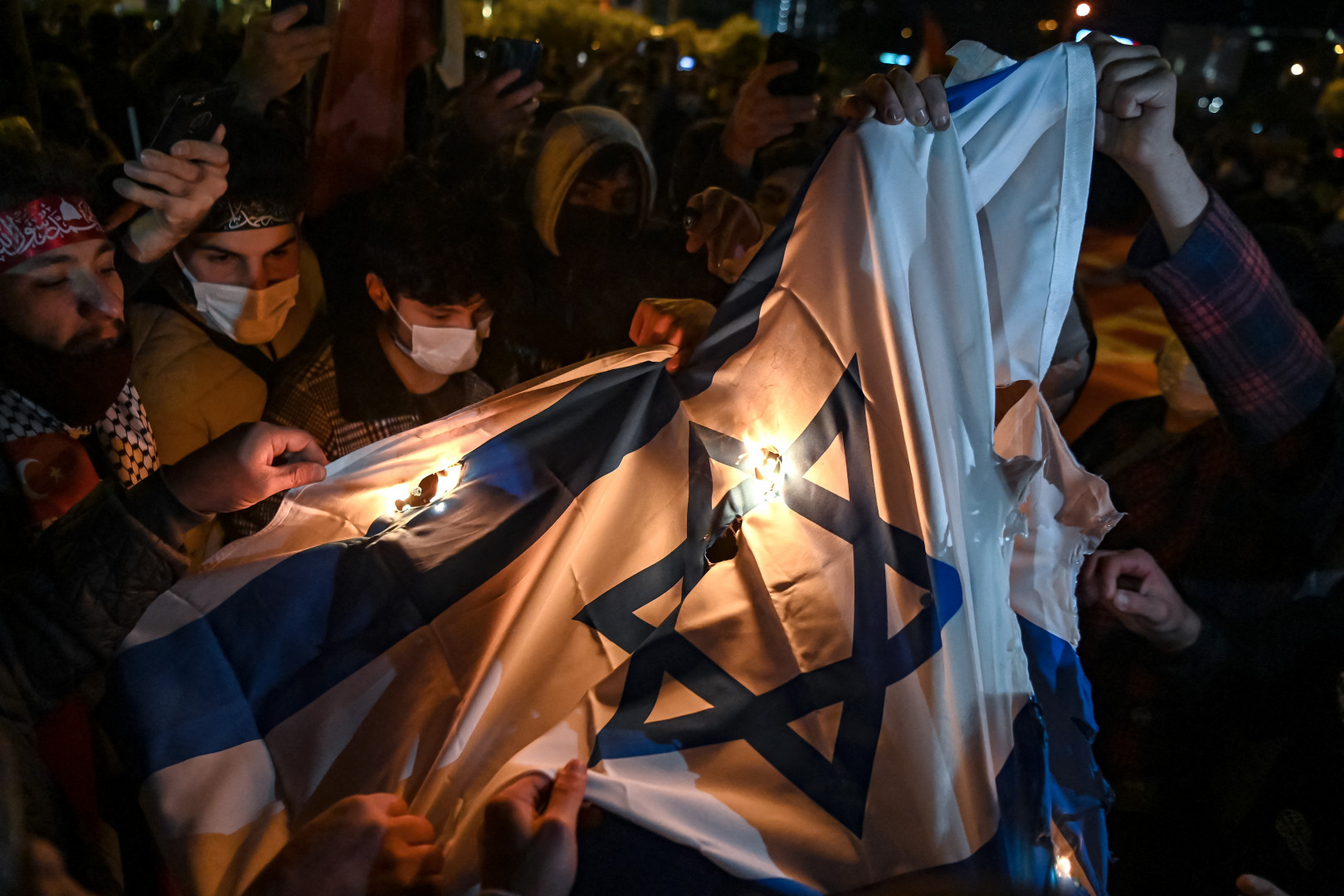 A Gázai övezet elleni légicsapások ellen demonstráló tüntetők felgyújtanak egy izraeli zászlót az ország isztambuli konzulátusa előtt május 11-én – Fotó: Ozan Kose / AFP