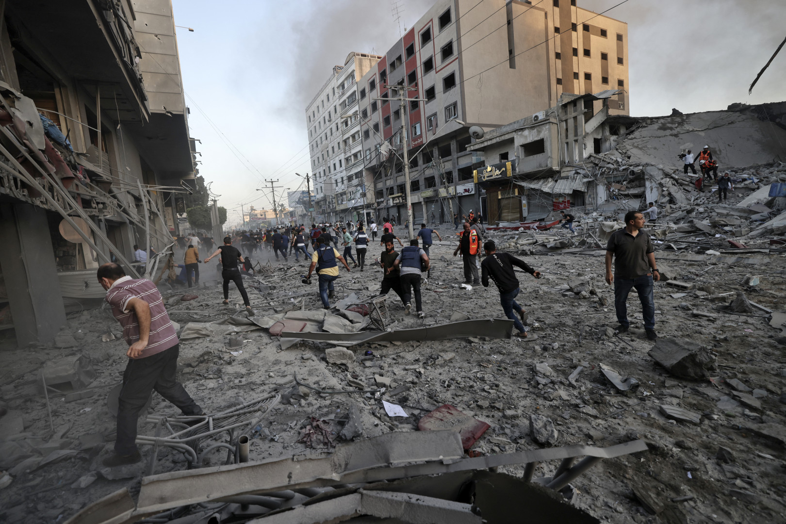 Mentőegységek és civilek Gázaváros utcáin az al-Saruk toronyház törmelékei között, melyet egy izraeli légicsapás rombolt porig május 12-én – Fotó: Mohammed Abed / AFP