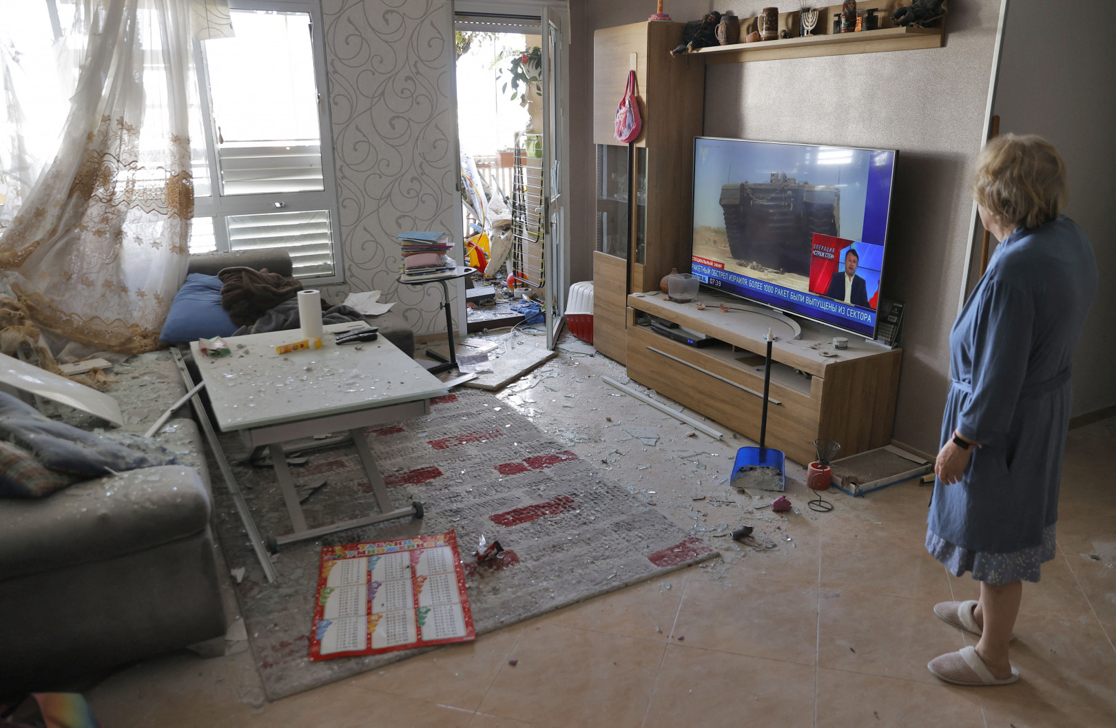 Egy Askelonban élő nő vizsgálja a lakásában okozott károkat egy palesztin rakéta becsapódása után május 14-én – Fotó: Jack Guez / AFP