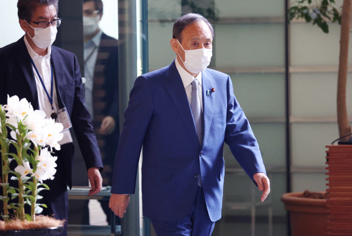 Szuga Josihide japán kormányfő érkezik a miniszterelnöki hivatalba június 2-án – fotó: Maszanori Genko / AFP