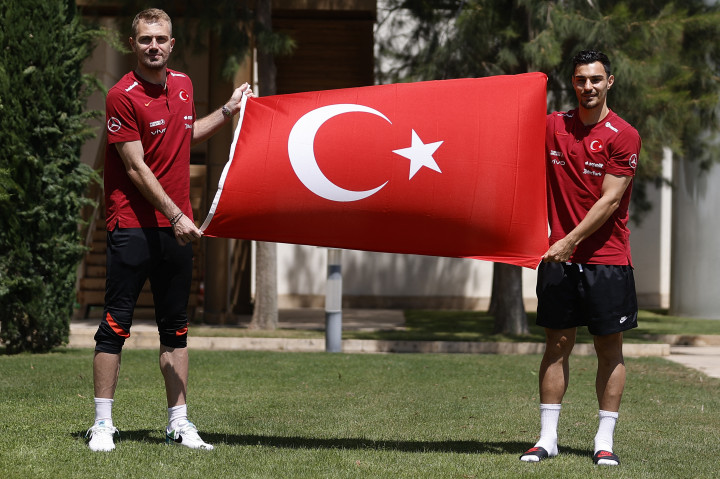 Mert Gunok kapus (b) és Kaan Ayhan (j), a török labdarúgó-válogatott játékosa a török zászlóval egy sajtótájékoztatót követően Antalyában 2021. május 29-én – Fotó: Mustafa Ciftci / Anadolu Agency via AFP