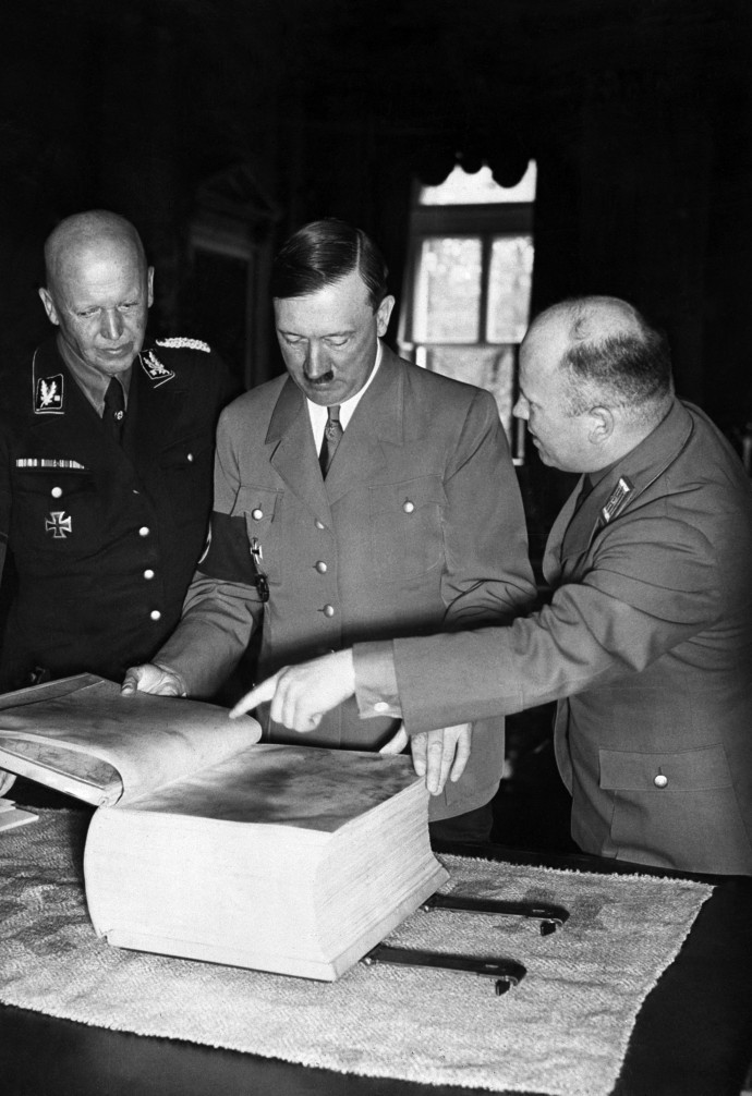Adolf Hitler nézi a Mein Kampf pergamenre nyomtatott kiadását. A kép készítésének dátuma ismeretlen – Fotó: STAFF / AFP
